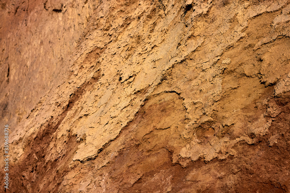 Texture of different layers of clay on the edge of a cliff. Closeup