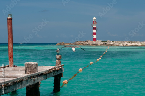Old wooden pier and red and white lighthouse at Cancun, Caribbean sea, Mexico © Marco B.