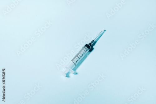 Syringe and needle on blue background. Injections and vaccination concept. Health protection equipment during quarantine Coronavirus pandemic