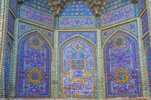 Famous pink mosque decorated with mosaic tiles and religious calligraphic scripts from Persian Islamic Quran, Shiraz, Iran. 