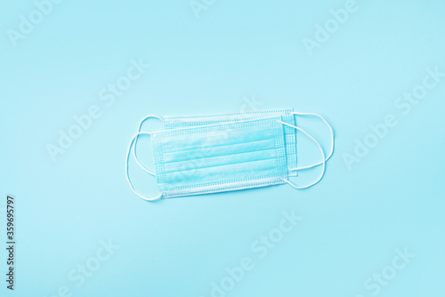 Surgical face mask on blue background with copy space. Minimal medical concept. Medical equipment. Products to stay safe during pandemic covid19 quarantine.