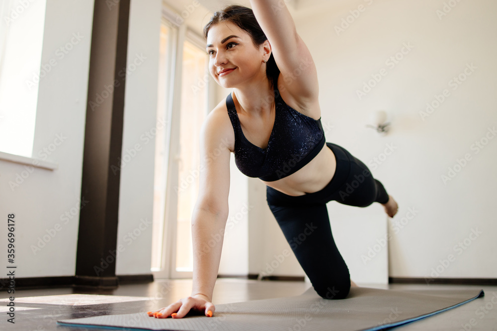 Obraz premium Home yoga. Fit woman doing exercises on fitness mat. Balance, body and mental health, self development
