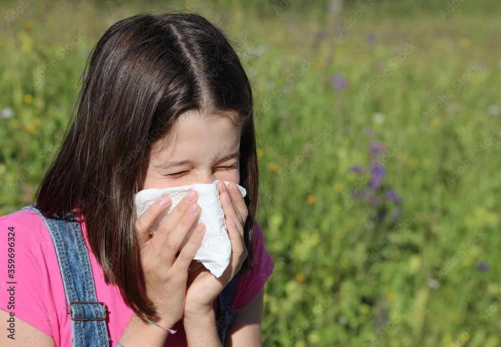 young girl sneezes and blows her nose with white handkerchief young girl sneezes and blows her nose with white handkerchief