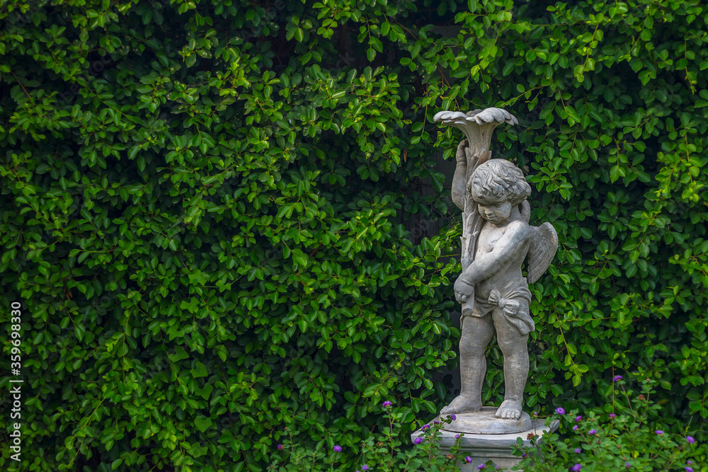 Ancient cupid statues and leaves background