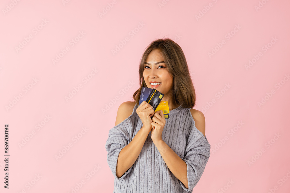 Asian woman holding a credit card She is thinking of shopping Asian woman holding a credit card She is thinking of shopping