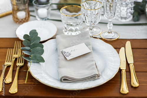 Decorated plate with fork and spoon. Table set up in boho style with pampas grass and greenery