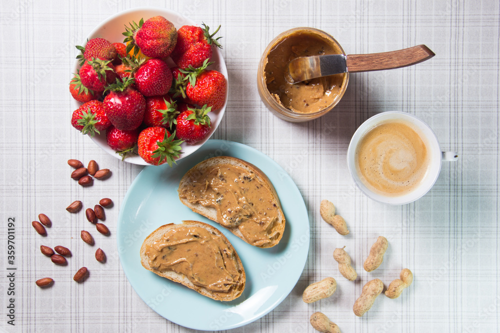 Breakfast with coffee and sandwiches with peanut paste and strawberries Breakfast with coffee and sandwiches with peanut paste and strawberries