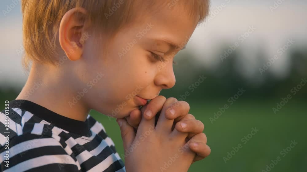 Happy child. The little boy closed his hands, closed his eyes in prayer. A lonely child in isolation, in hope. Happy child. The little boy closed his hands, closed his eyes in prayer. A lonely child in isolation, in hope.