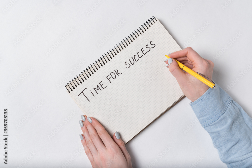 Female hands writes in notepad TIME FOR SUCCESS. White background. Female hands writes in notepad TIME FOR SUCCESS. White background.