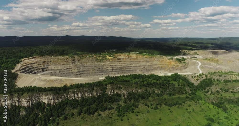 Industrial of opencast mining quarry with lots of machinery at work / quarry green in Ural Mountains. Extraction of iron, copper, gypsum, calx, magnesite. Aerial drone wide view at summer sunny day Industrial of opencast mining quarry with lots of machinery at work / quarry green in Ural Mountains. Extraction of iron, copper, gypsum, calx, magnesite. Aerial drone wide view at summer sunny day