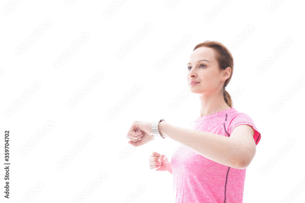 スマートウォッチを確認するスポーツウェアを着た若い女性
