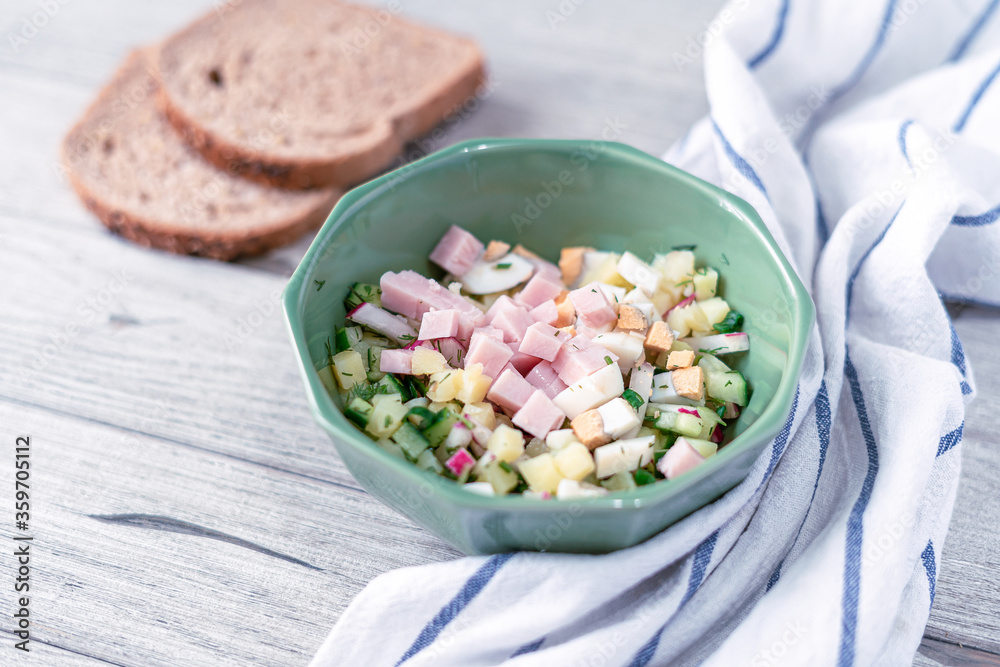 Traditional russian cold soup okroshka ingredients with some of its cooking components on a gray wooden background with bread. Salad with copy space Traditional russian cold soup okroshka ingredients with some of its cooking components on a gray wooden background with bread. Salad with copy space