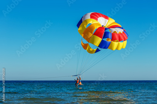 Tourists fly over the sea on a parachute