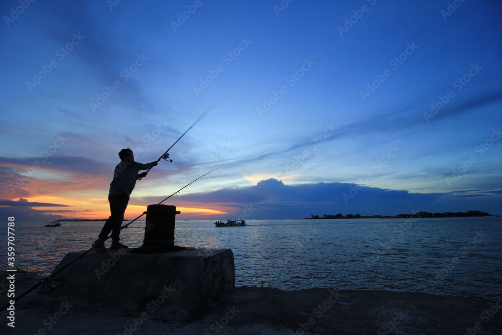 The silhouette of fishing at sunset