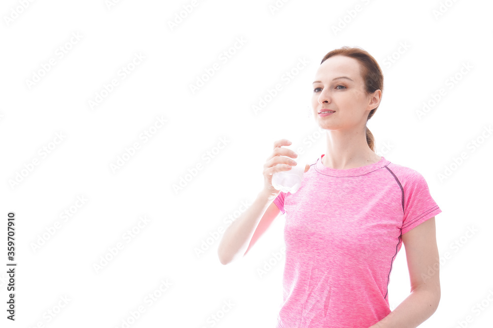 水分補給をするスポーツウェアを着た若い女性 水分補給をするスポーツウェアを着た若い女性