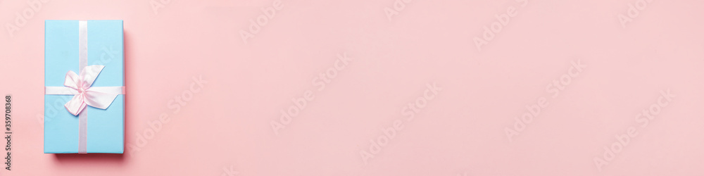 Christmas New Year birthday valentine celebration present romantic concept. Simply minimal design blue gift box isolated on pink pastel colorful background. Flat lay top view copy space, banner