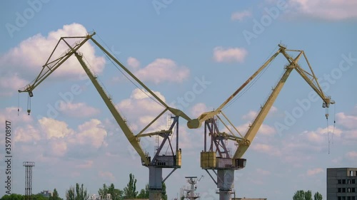 Wallpaper Mural A plant with large cranes on a background of clouds. Modern cranes for shipbuilding Torontodigital.ca
