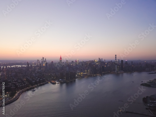Wide Aerial Drone View of Manhattan Skyline with East River in New York City at Dusk and City Lights