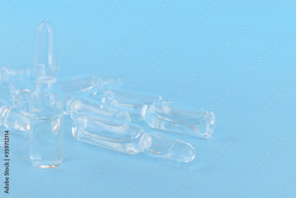 several ampoules with colorless medicine on a blue background several ampoules with colorless medicine on a blue background
