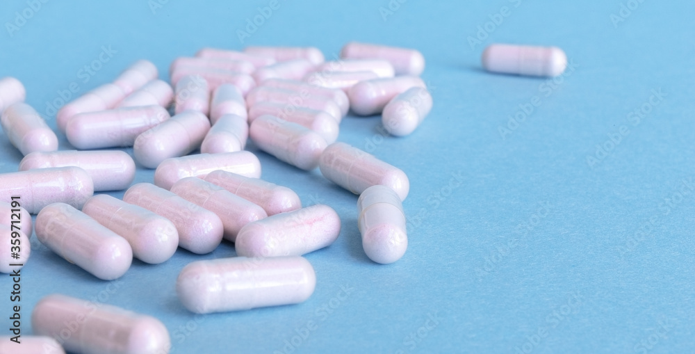 pink pills scattered on a blue background
