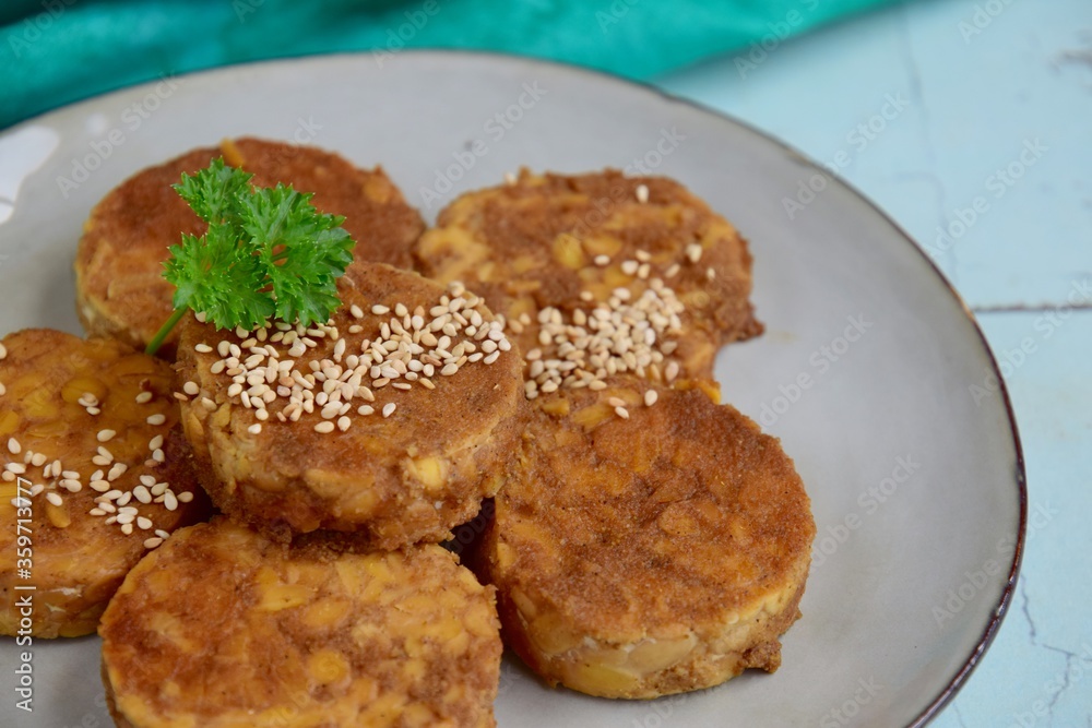 Slices of tempeh (fermented soybean) on the wooden board Slices of tempeh (fermented soybean) on the wooden board