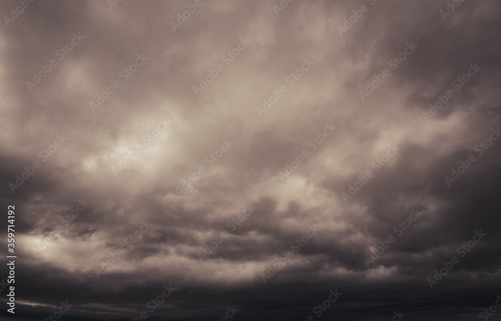 Fototapeta premium Gray storm clouds fill the dark horizon as grey clouds fills the fear inducing sky above.