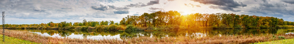 Panorama beautiful sunset over autumn forest and lake Panorama beautiful sunset over autumn forest and lake
