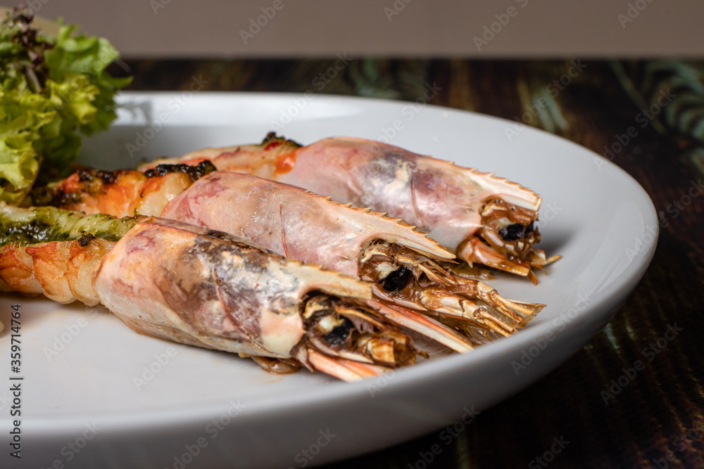 Langoustines with young potatoes. A dish with large king prawns, lobsters with vegetables. Seafood with a panel, a delicious seafood delicacy, a source of omega 3 Langoustines with young potatoes. A dish with large king prawns, lobsters with vegetables. Seafood with a panel, a delicious seafood delicacy, a source of omega 3