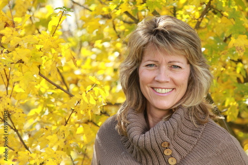 Happy mature woman with pullover in autumn photo