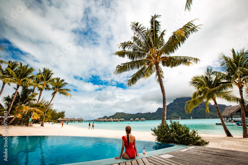 Beautiful blonde girl posing in pool on tropical island