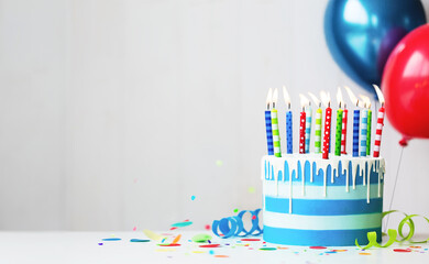 Colorful birthday cake with candles and balloons