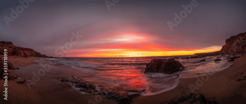 Atardecer rojo en una playa desierta