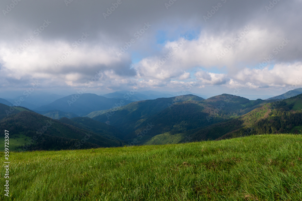 Green meadow in mountain and blue cloud sky. Composition of nature. Spring meadow. Composition of nature. Slovakia