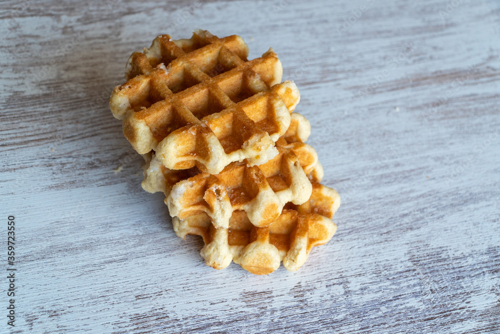 A delicious baked round Belgian waffle with one bite taken.