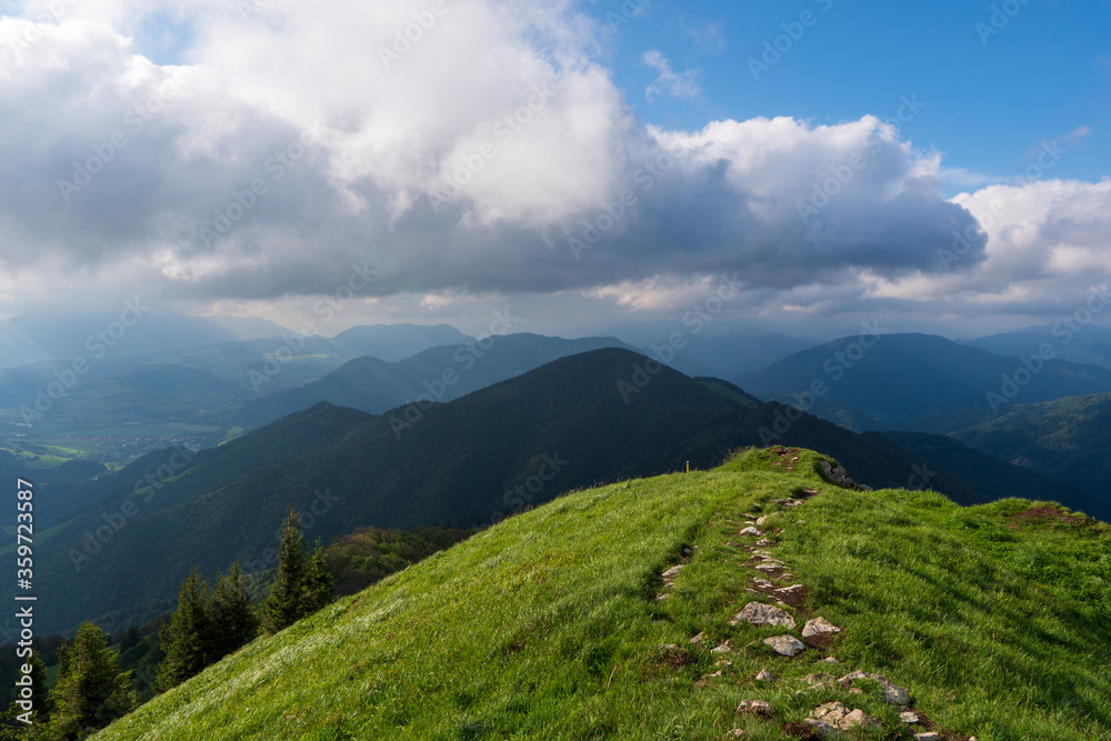 Obraz premium Green ridge in mountain and blue cloud sky. Composition of nature. Spring ountain. Composition of nature. Slovakia little fatra europe