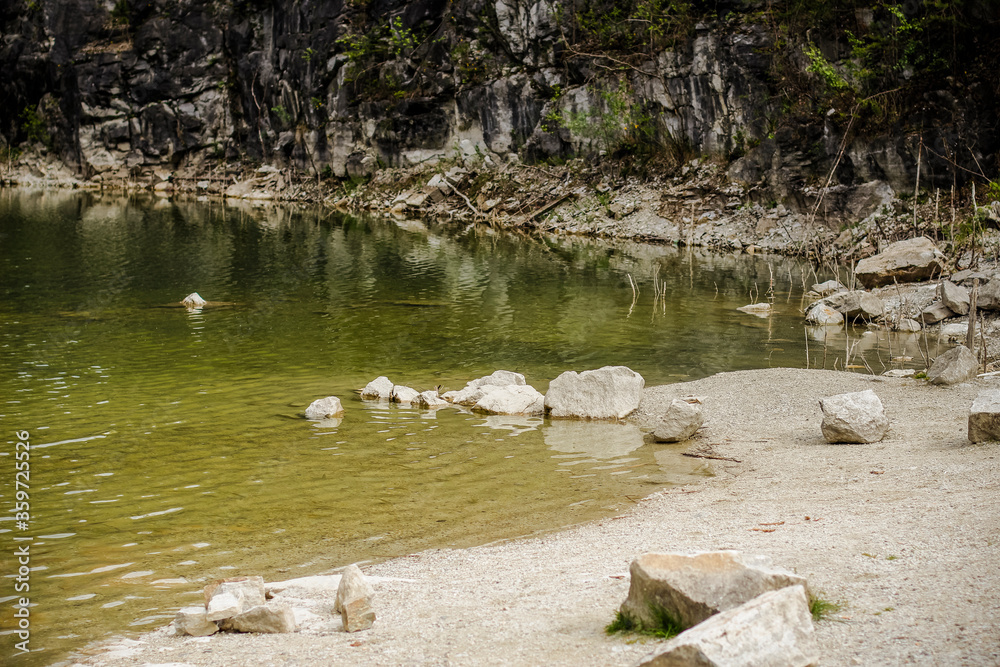 Stone beach with water surface and rock in the background Stone beach with water surface and rock in the background