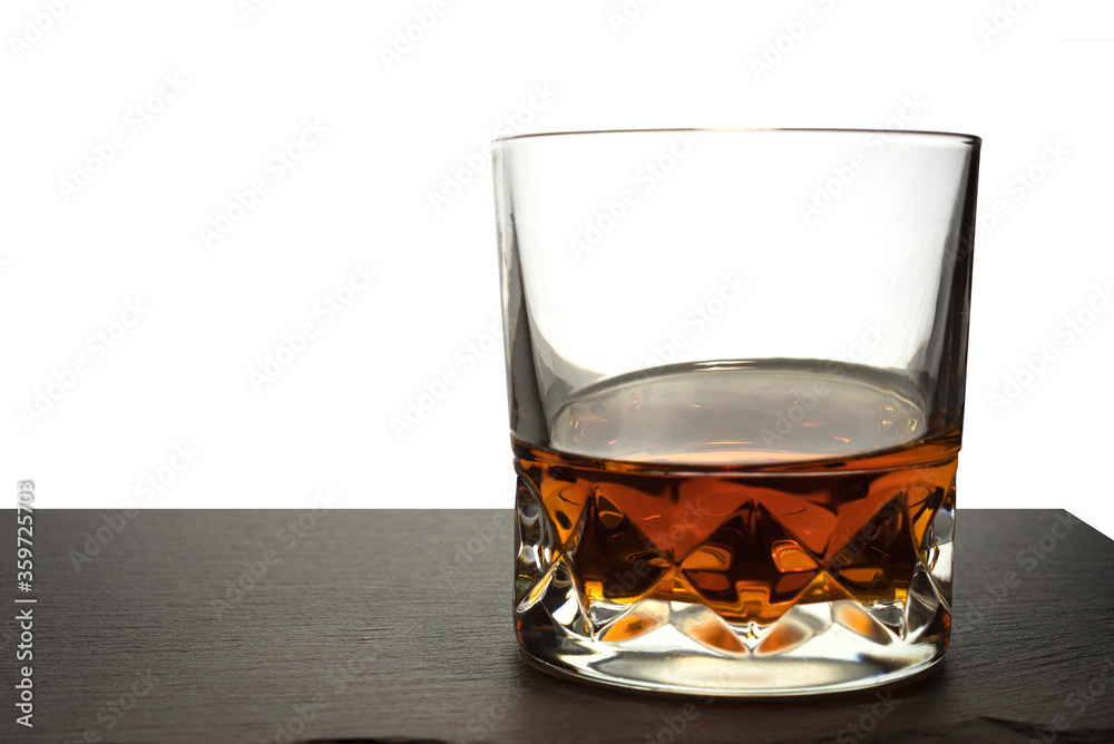 Cognac or Bourbon or rum or whiskey in glass glasses on a dark stone background Cognac or Bourbon or rum or whiskey in glass glasses on a dark stone background