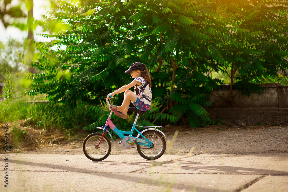 Young little girl learning to ride bike in park