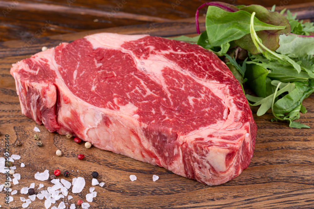 Raw meat, Ribai steak with spices on a wooden board with greenery
Raw meat, Ribai steak with spices on a wooden board with greenery