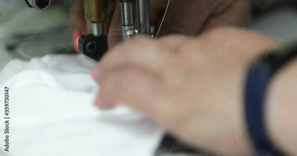 Needle Of Sewing Machine Used By A Seamstress In Sewing White Fabric Mask In A Garment Industry - extreme close up Needle Of Sewing Machine Used By A Seamstress In Sewing White Fabric Mask In A Garment Industry - extreme close up