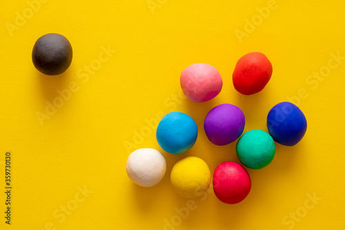 Fotografia Black plasticine ball excluded from other balls in many colors