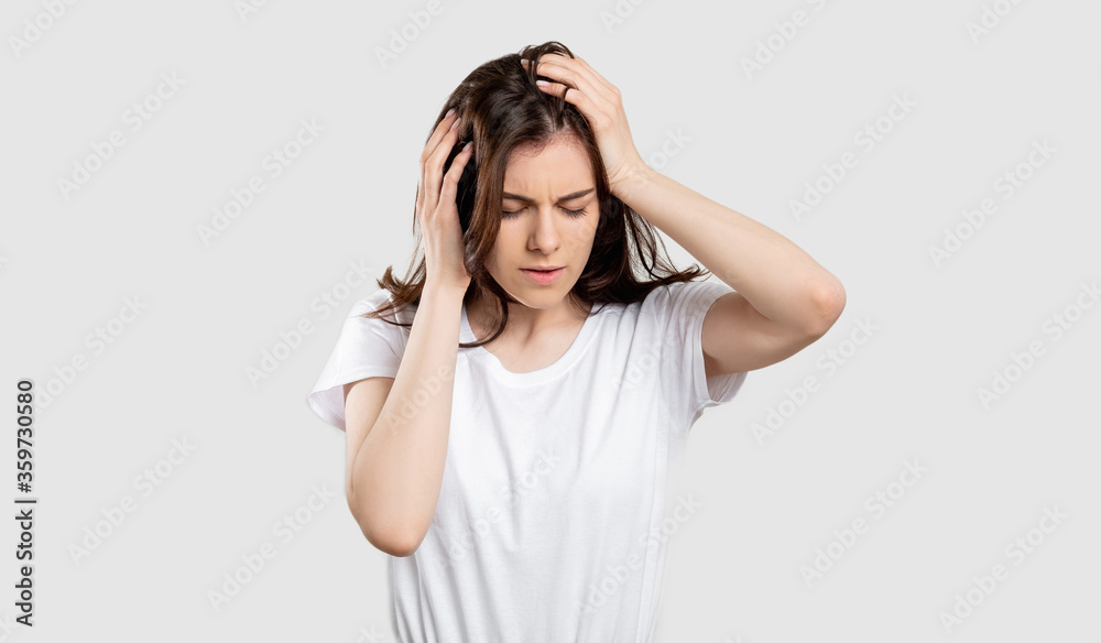 Suffering woman portrait. Migraine pain. Stressed out lady touching head isolated on neutral background. Suffering woman portrait. Migraine pain. Stressed out lady touching head isolated on neutral background.