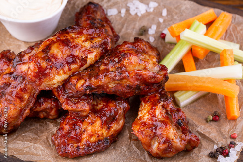 Chicken wings in a grilled sauce with fresh vegetables