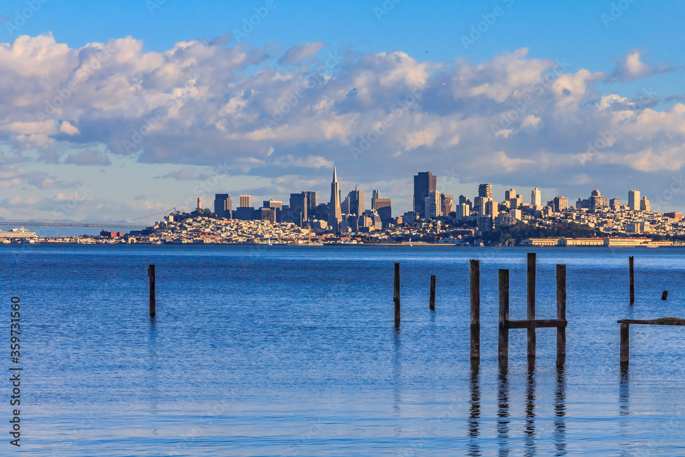 Fototapeta premium San Francisco skyline with the Bay Bridge in the background and pylons of an old pier from Sausalito, circa 2011