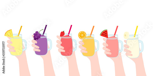 Hand is holding​ the smoothies juice in a glass cup with and has fruit on top. A cold soft drink for summer. Healthy beverage. A takeaway Product advertisement.