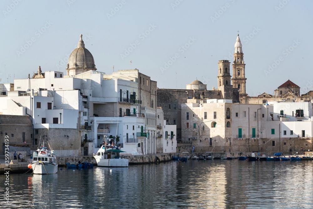 Beautiful boats in Monopoli port near Castle of Carlo V with church in background, Apulia, Bari province, Italy