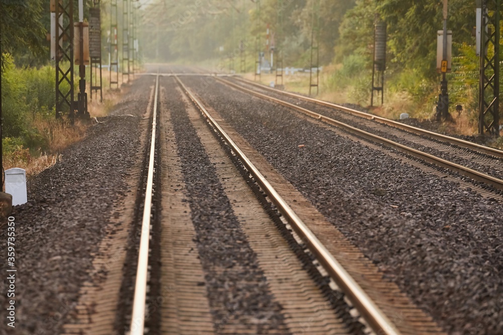 Train line rails railway track with sunlight flare Train line rails railway track with sunlight flare