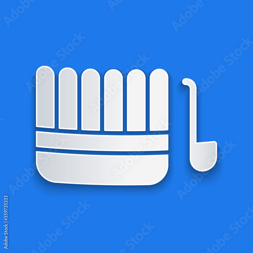 Paper cut Sauna bucket and ladle icon isolated on blue background. Paper art style. Vector Illustration