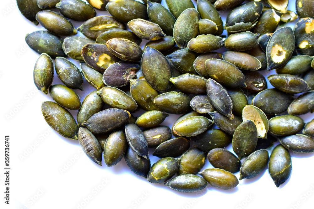 Fried delicious peeled pumpkin seeds on a white plate Fried delicious peeled pumpkin seeds on a white plate