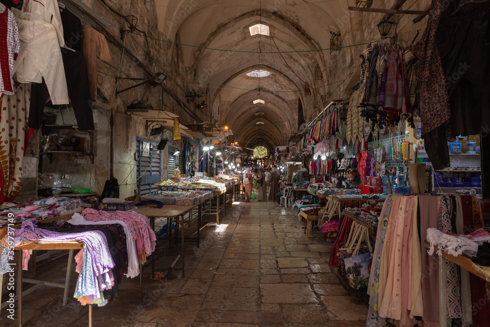 The Arab market with all kinds of souvenirs for tourists and locals on Al-Qattanin street in the Arab Quarter in the old city of Jerusalem, Israel